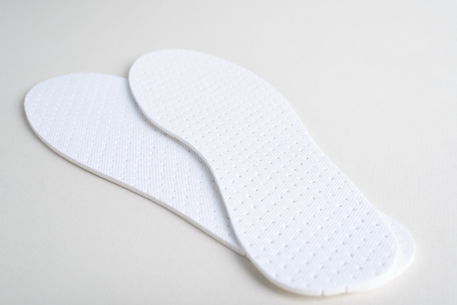 Selbstklebendes Fersenpolster wird in einen Schuh eingelegt